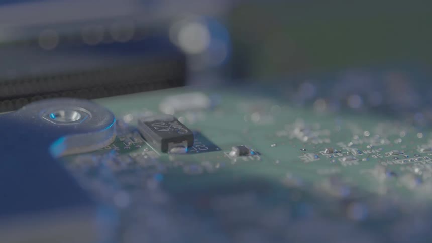 An electronic board with some electronic components on top of it and there is a shadow passing by