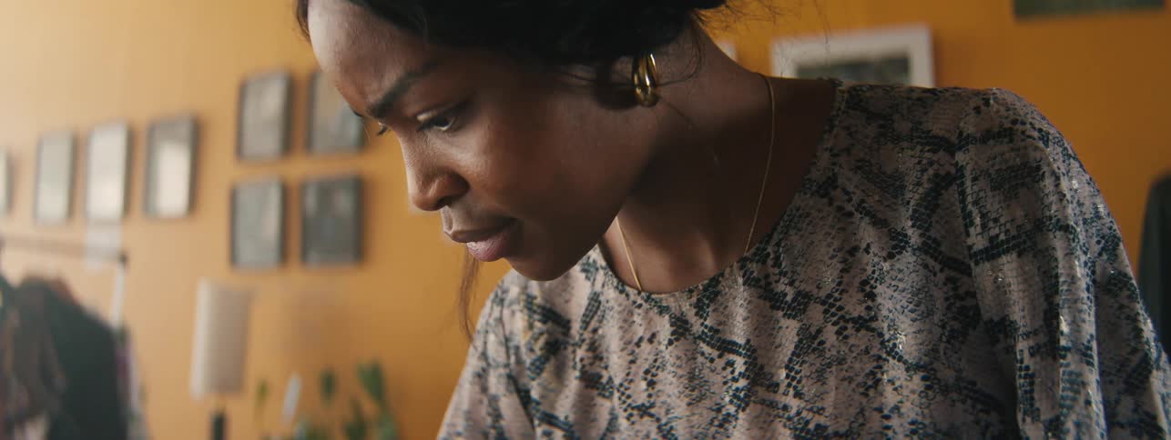 The face of a woman who is looking down intently and then gives a microsmile
