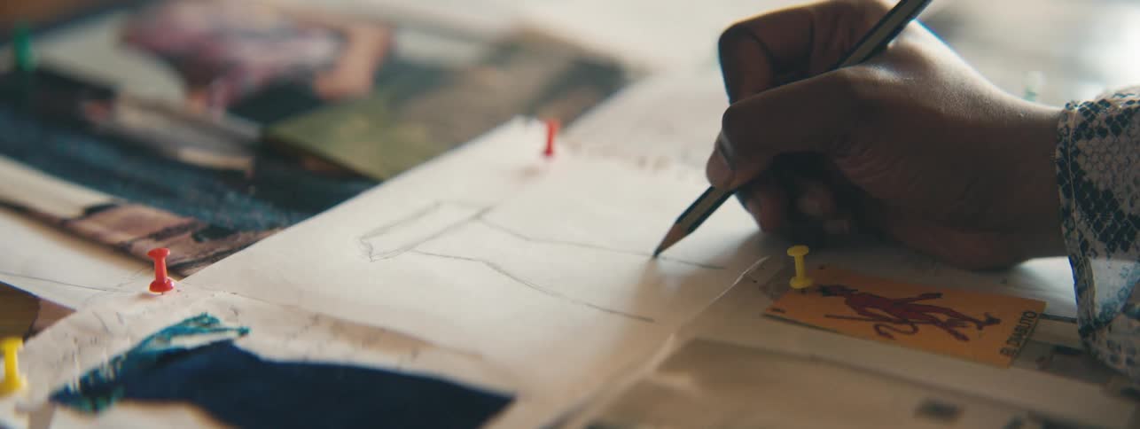Female hand drawing the silhouette of a dress