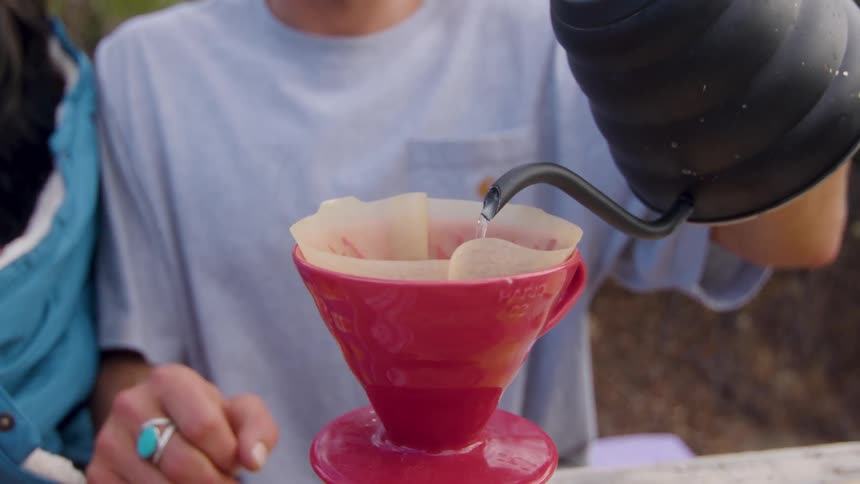 Close up of a teapot with water pouring water into a coffee filter