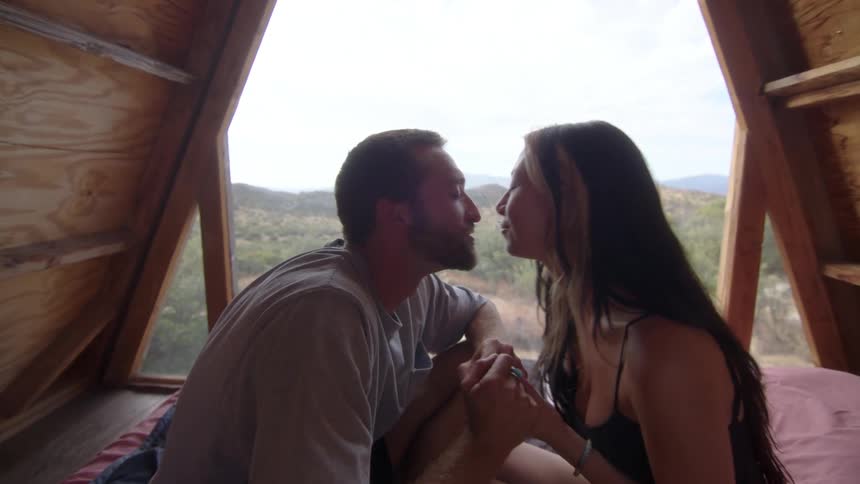 Couple in a camping cabin sitting and kissing
