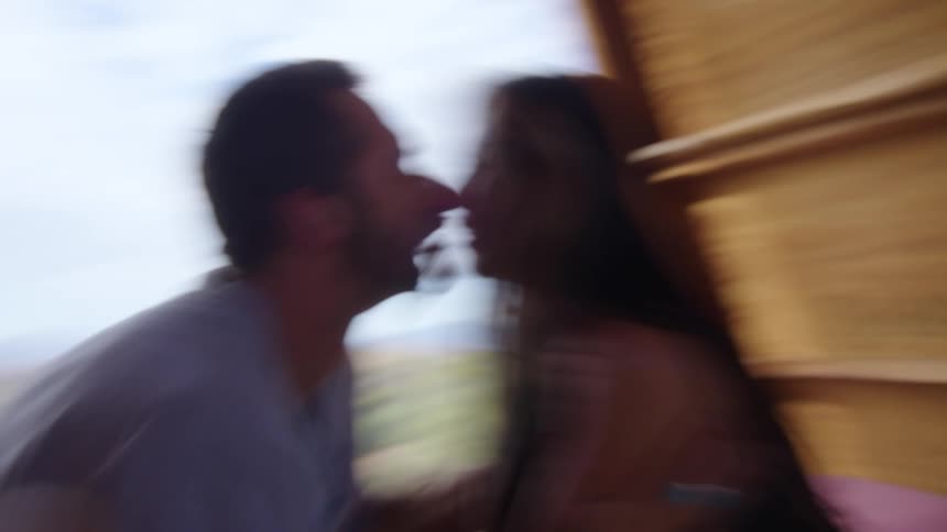 Man and woman inside a cabin kissing