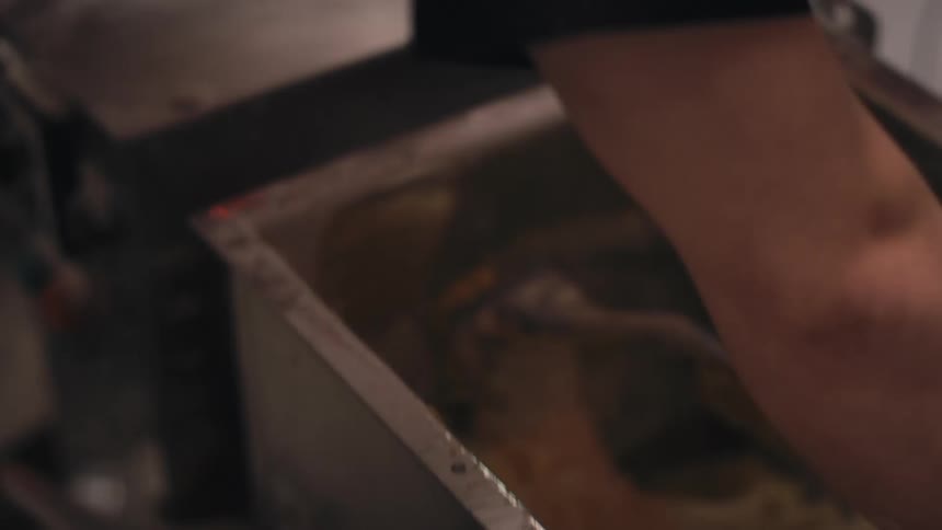 Man in a restaurant preparing a dough inside an industrial metal container