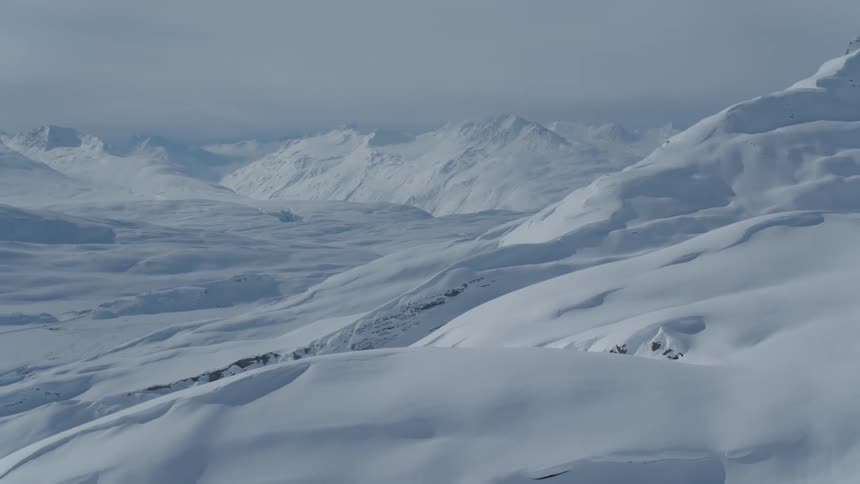 Vast serene snowcovered landscape with rolling hills completely covered in a thick layer of snow stretches into the distance