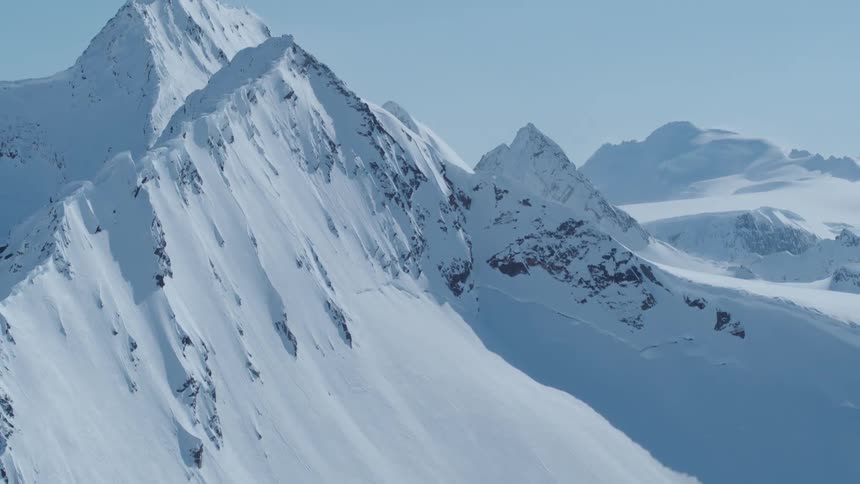 Aerial view of snow covered mountains on a blue sky day