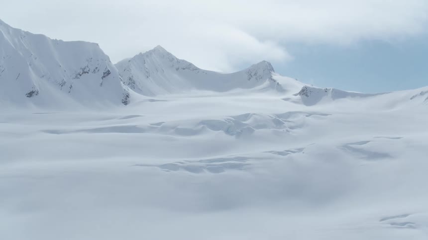 Layers of snow covering mountains on a cloudy day