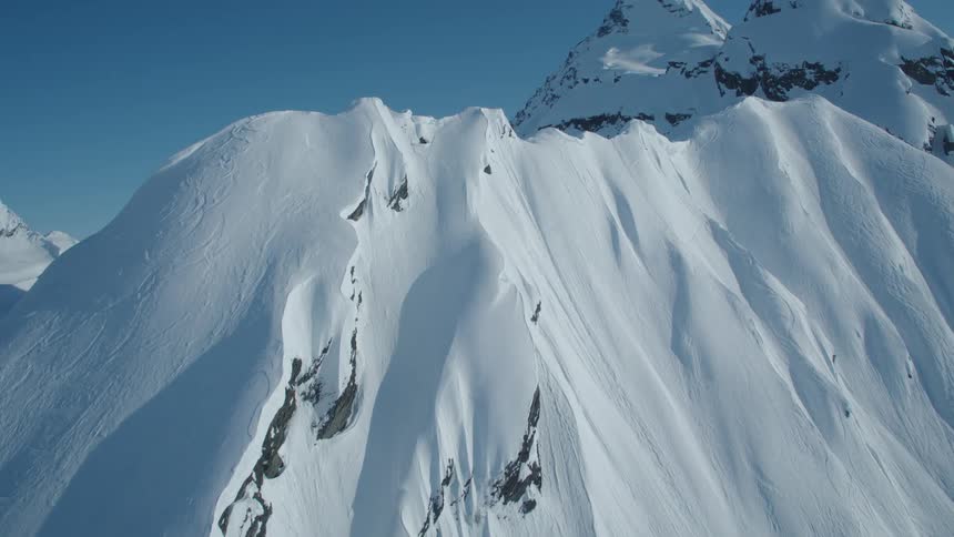 Large mountain with cliffs and layers of snow
