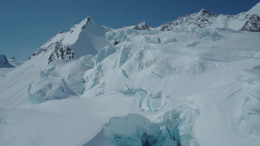 A snowy mountainous landscape with rugged icecovered peaks and crevasses