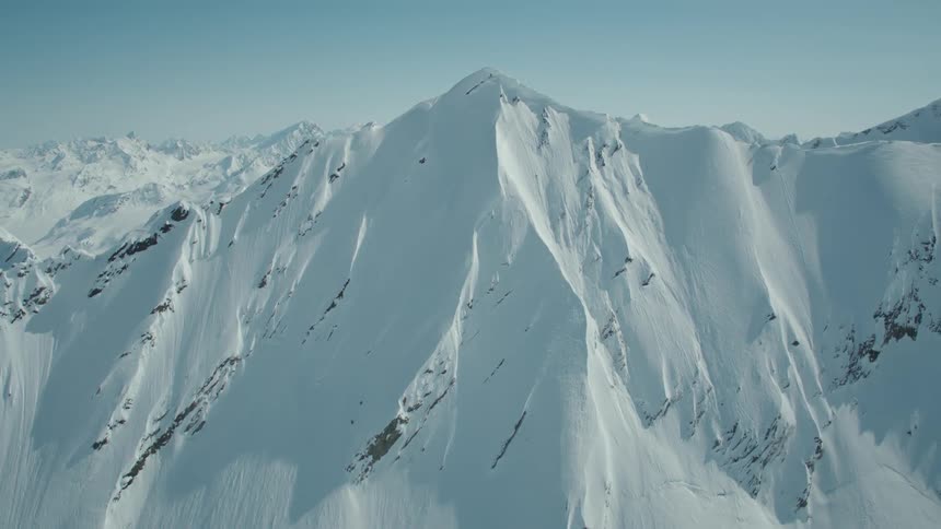 Aerial panorama of snowy mountains on a clear blue sky day