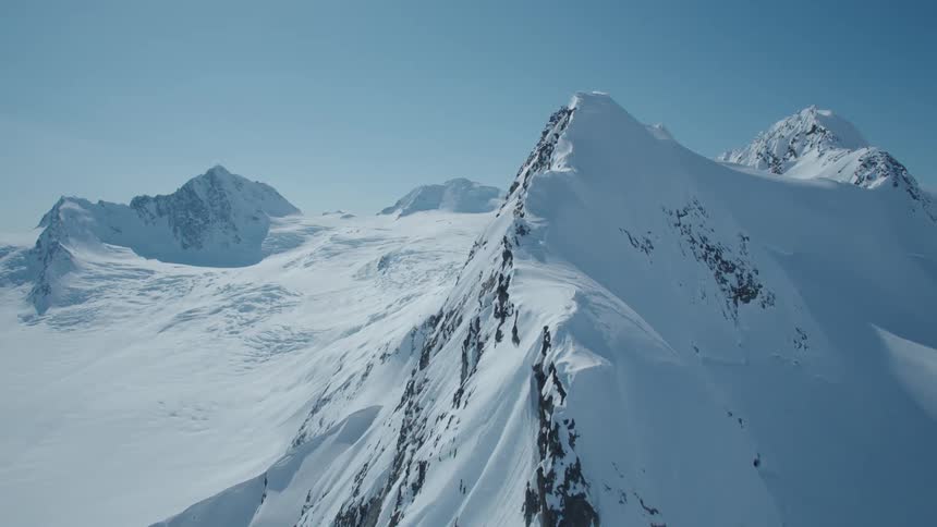 Snow covers mountain ridge and slopes on a sunny winter day