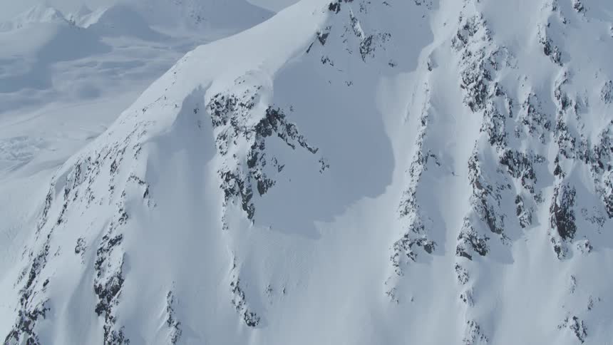 Aerial view of a person skiing down a large snowy mountain