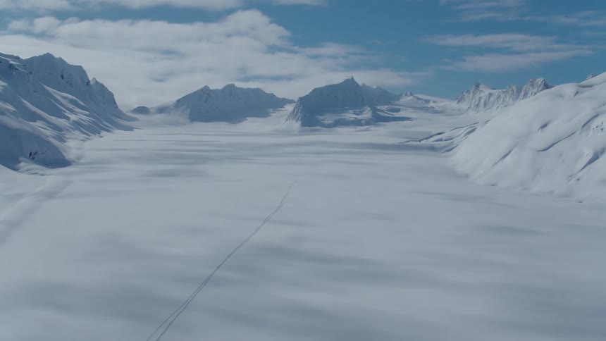 A huge region of land on the snow white plane and there are several mountains on the sides