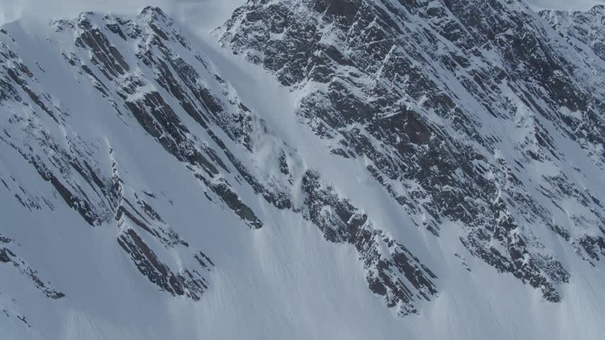 Rocky wall of a mountain covered in snow