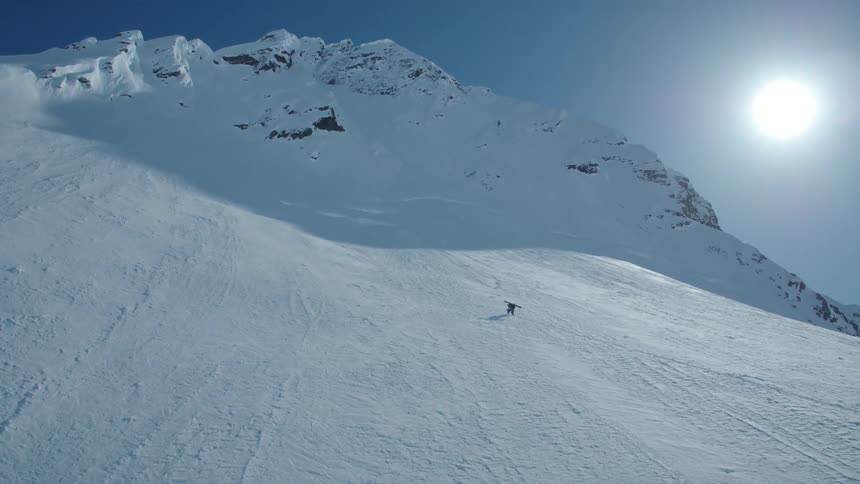 Person with ski equipment climbing a snowy mountain