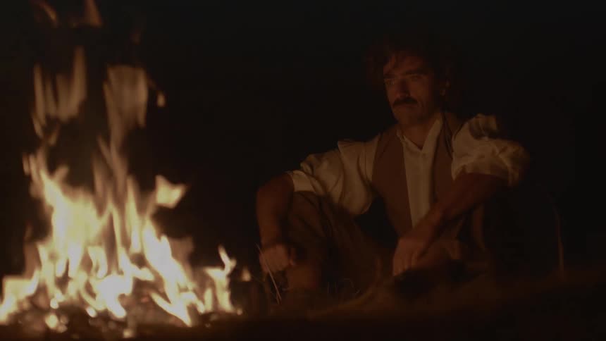 Angry man ripping of a necklace and throwing it into the bonfire
