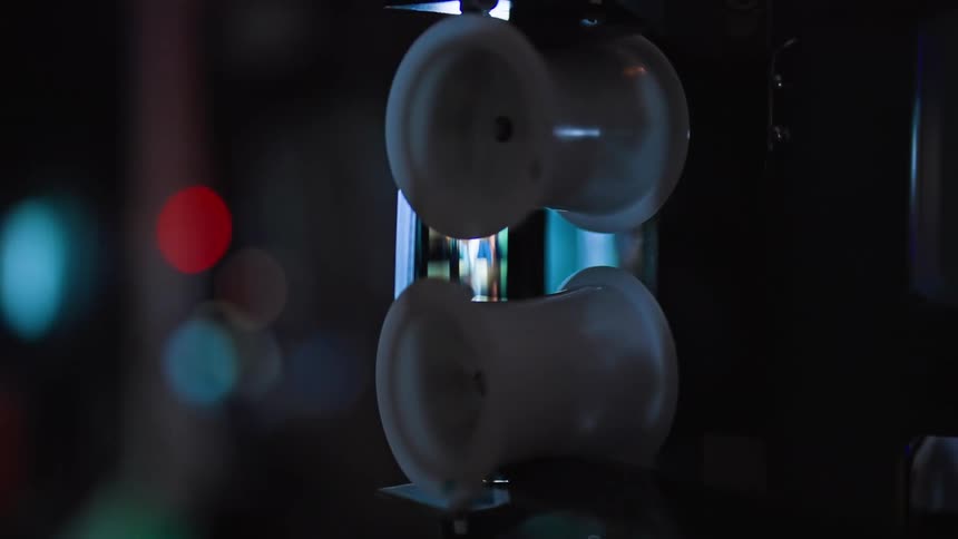 A film projector with the film spools in focus and a blurry background of lights