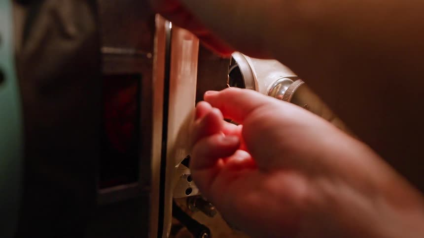 An employee replaces a part in a complex machine