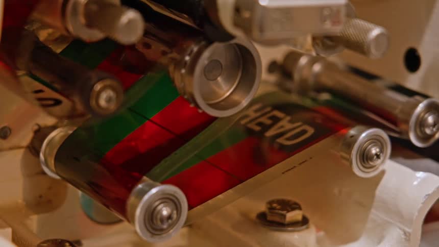 A pulley system pushing a green and red colored film