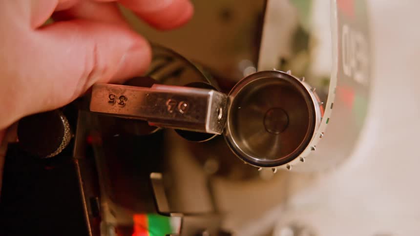 A person latches film into a projector