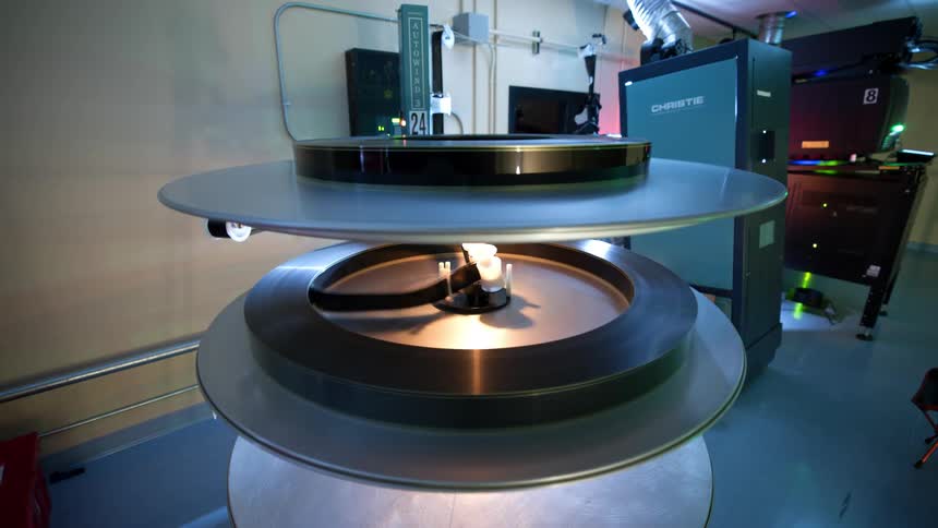 A film projector with a reel of film winding onto a spool