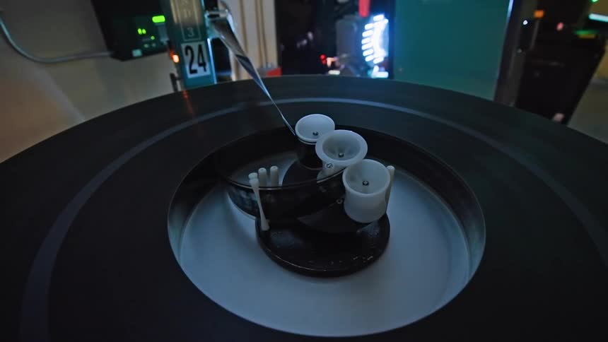 A large film reel spinning sideways on a modern projector