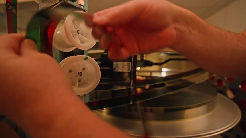A projectionist loads film into the projector