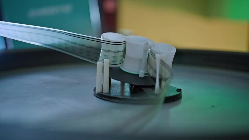 A film projector with a reel of film spinning on a spool