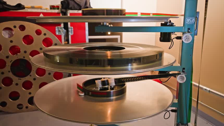 A film projector with large reels of film a film gate and a light source