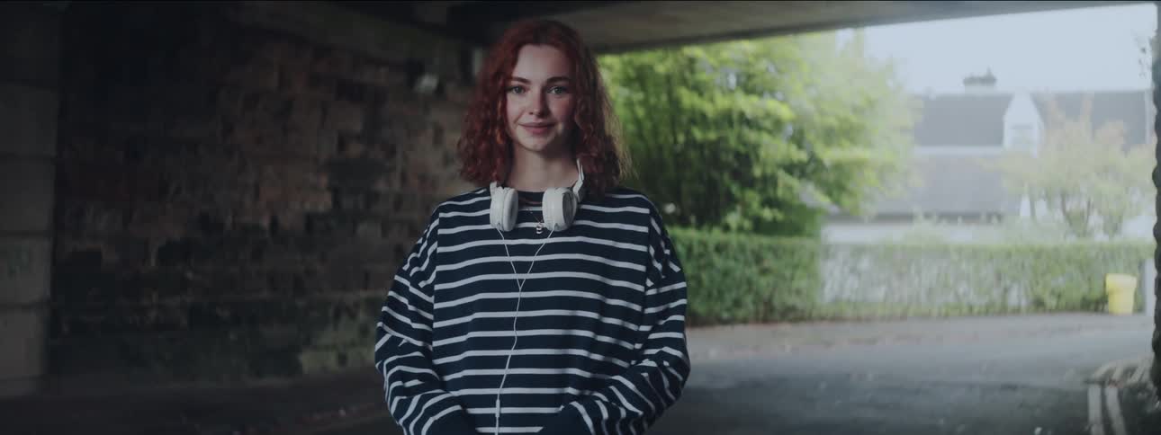 A woman is smiling under the overpass