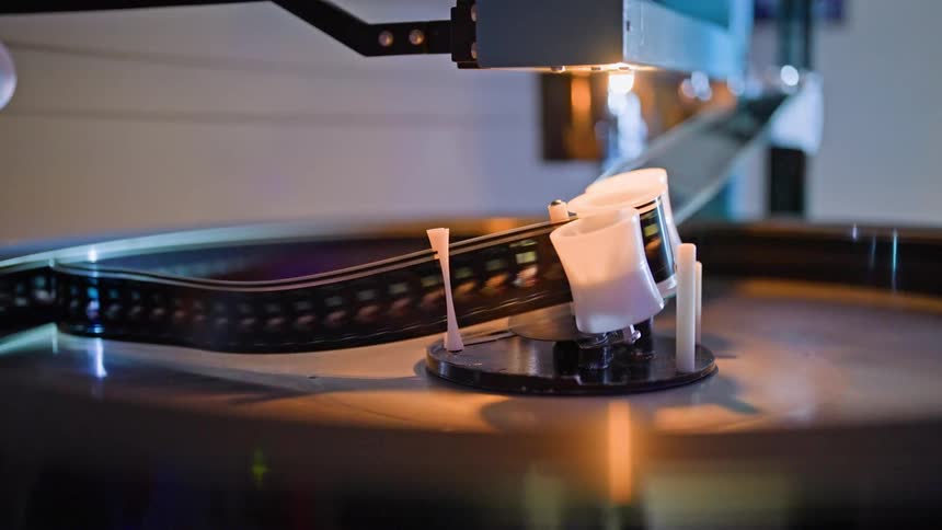 A film reel is running through the projector