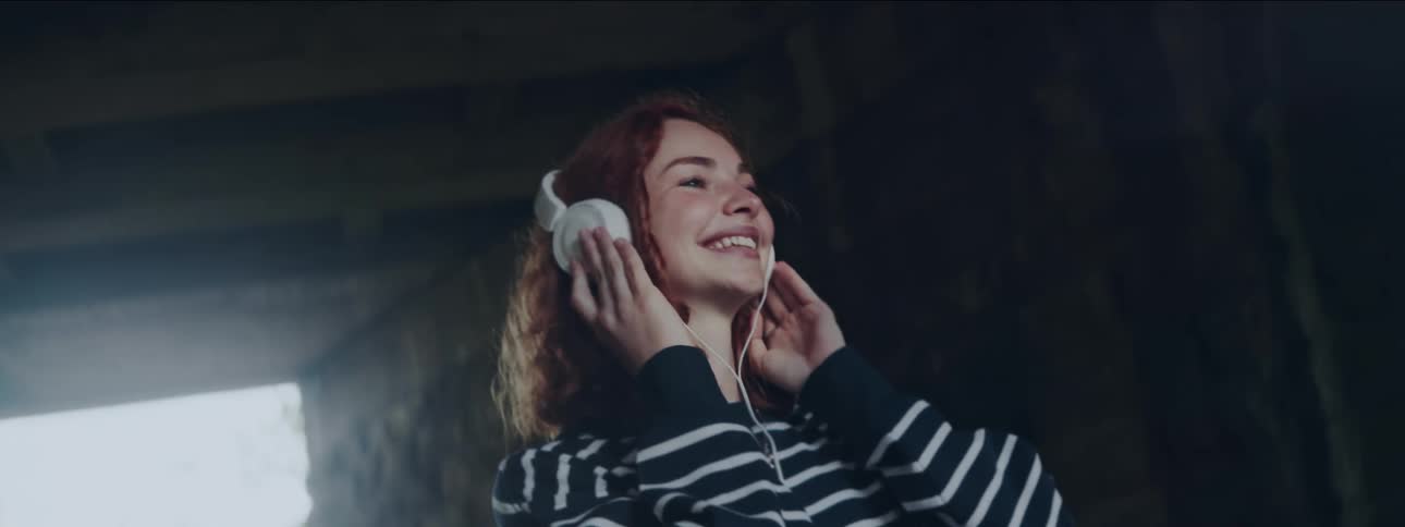 Redhead woman enjoying music on headphones