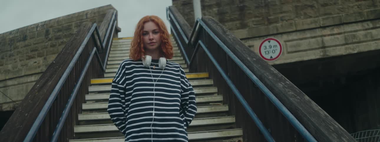 A clip of a redhead female standing by the staircase
