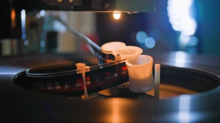 Close up of a machine with three white tubes that is rotating with a film strip