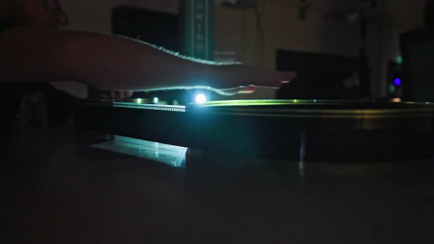 Hand placing a film strip into a machine in a dark room
