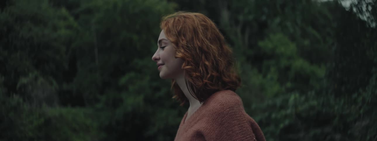 A woman smiles in the forest