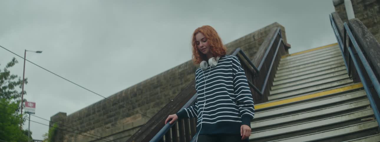 A woman walks down the staircase outside