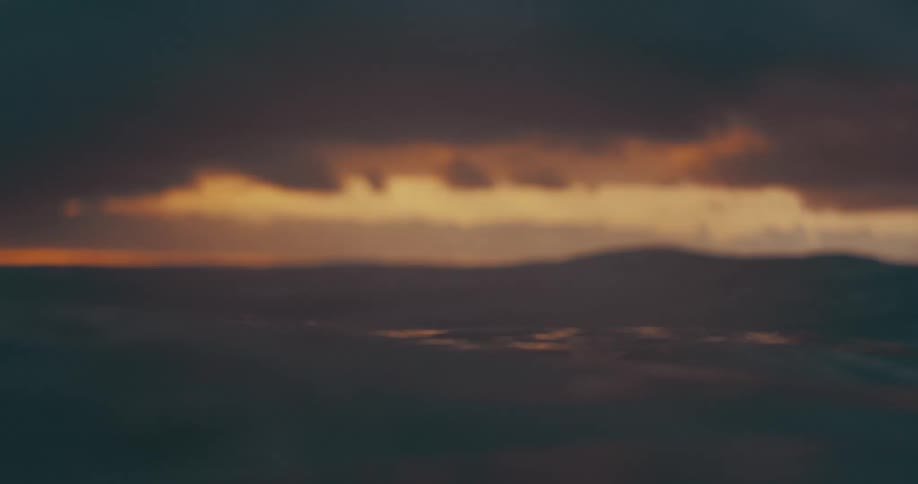 A close up of ocean waves under a dramatic sunset