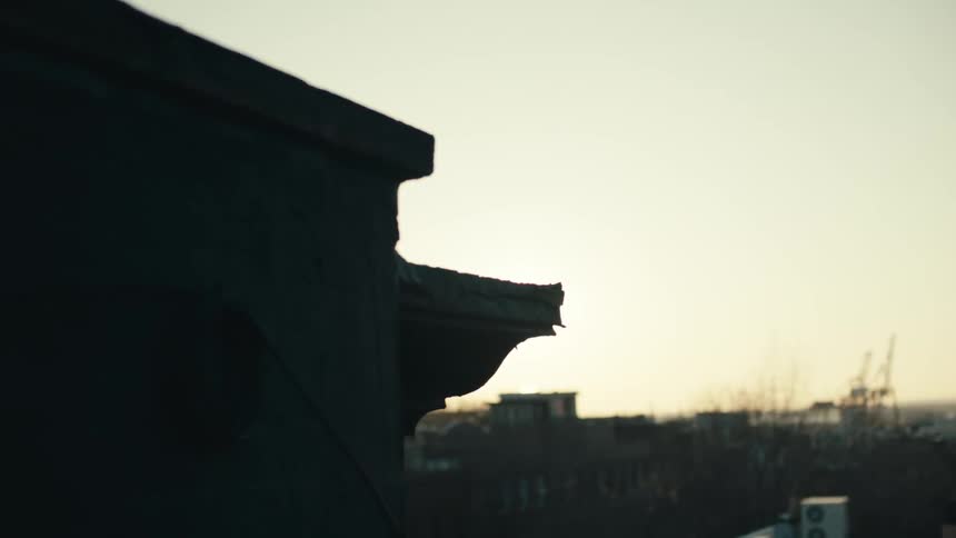 Sun peeking out behind a building