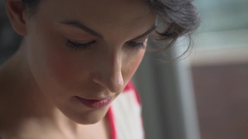 Woman's head bobbing as she is working on something out of view