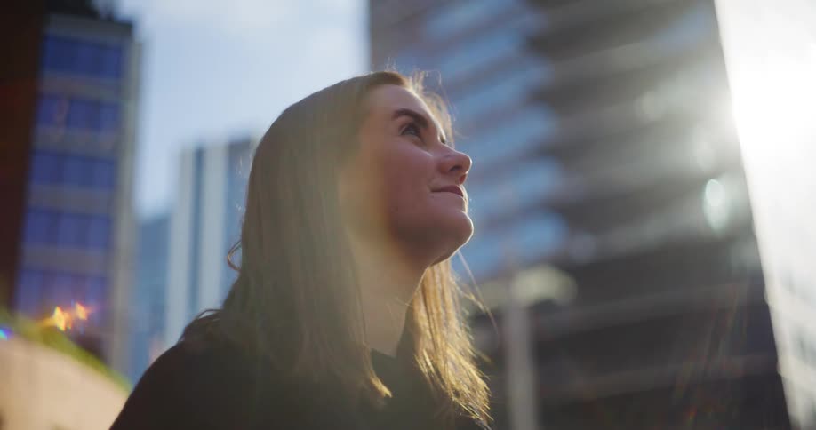 Woman looking up at buildings with happy facial expression