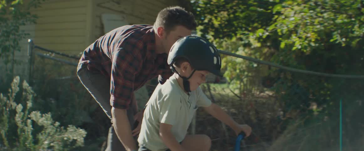 Father teaches his child how to ride a bicycle