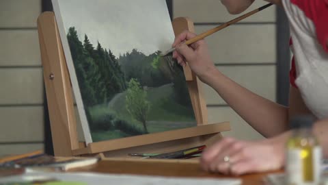 A woman painting a nature landscape