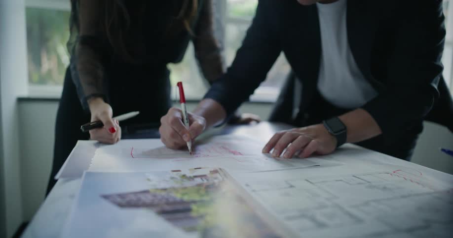 People work together on a large paper with several markings