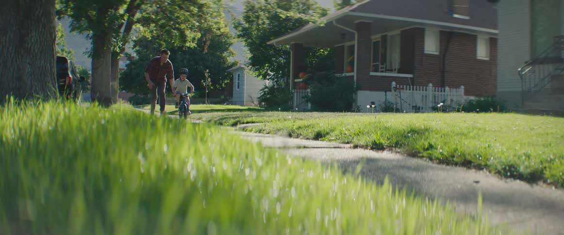 A clip of a man teaching a child how to ride bike