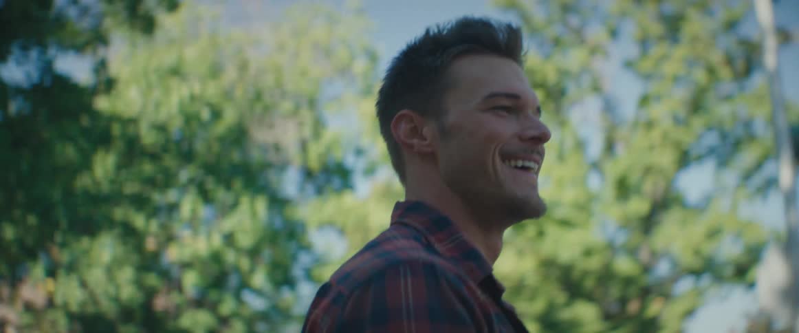 A man smiles and claps as he walks toward a neighborhood street corner