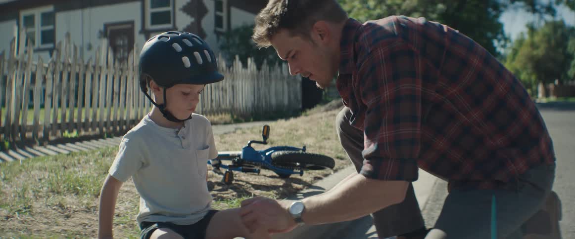 Father putting a bandaid on his son's knee and then they high five