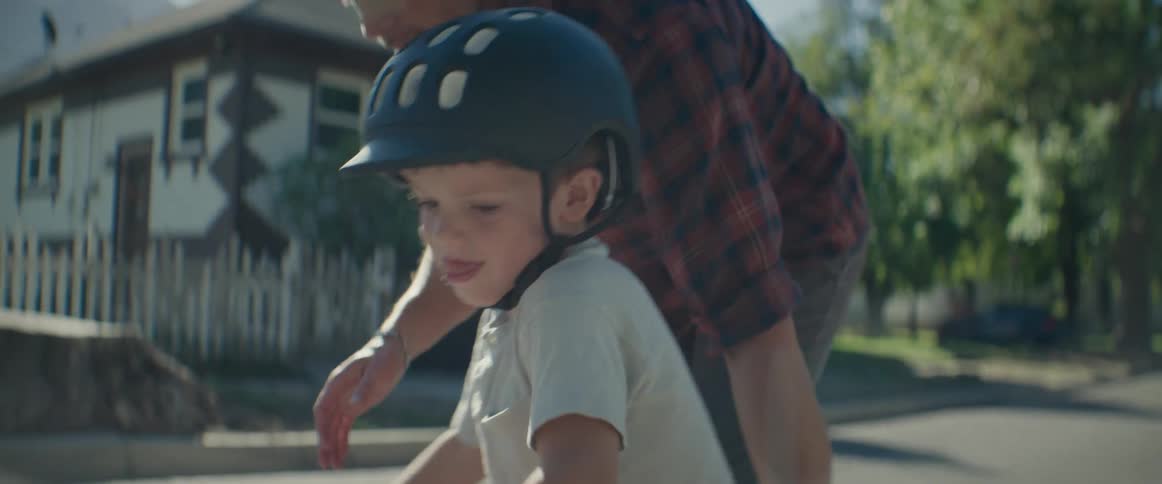Father helping his little son ride a bike