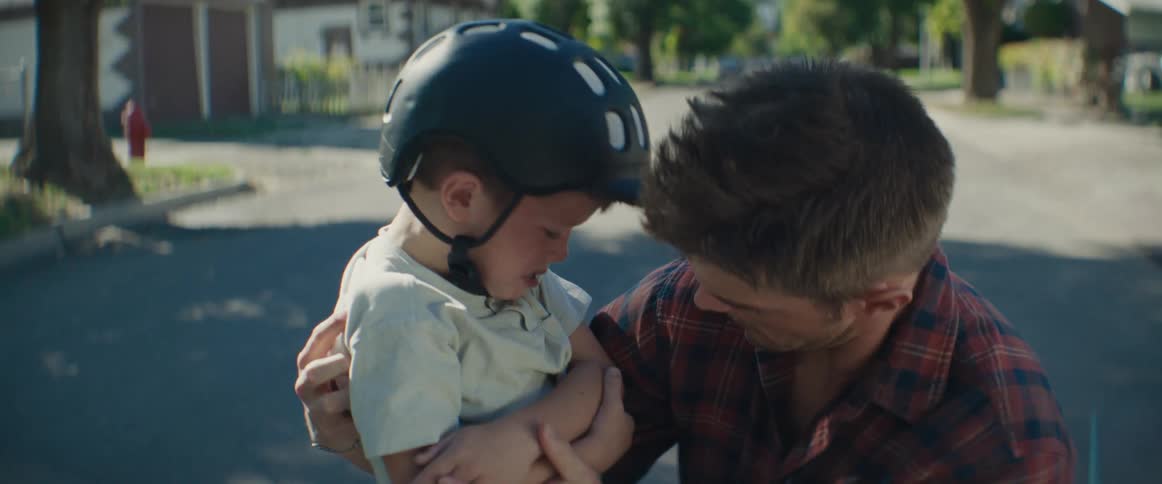 Father with his son who is crying and showing the wound on his arm