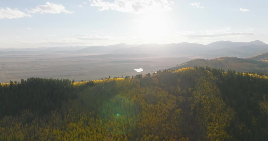 A mountain range stretches out under a bright blue sky