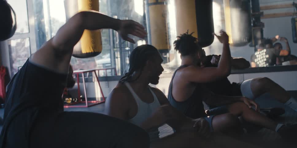 Four men clapping their hands while sitting in a gym